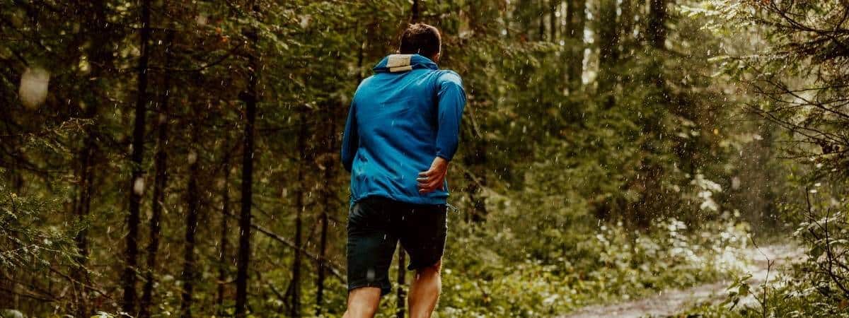 Man running in the rain in the forest